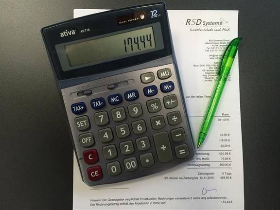 Steuervorteil durch Handwerkerleistung - Taschenrechner und Stift liegen auf Rechnung der RSD Systeme GmbH