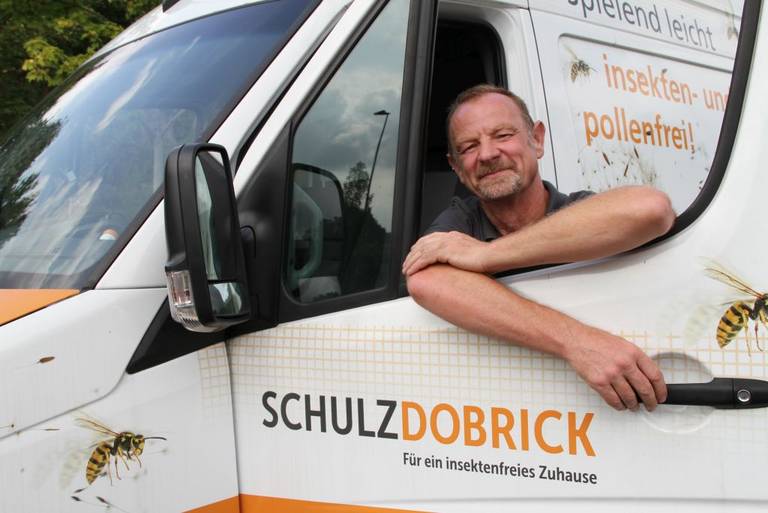 Ingo Freund, Monteur der Schulz-Dobrick GmbH am Fenster des Firmentransporter lehnend