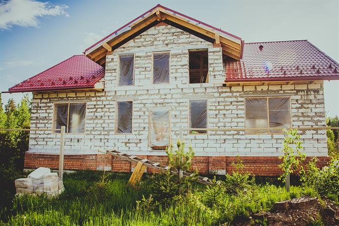 Haus im Bau noch ohne Fenster auf der gruenen Wiese
